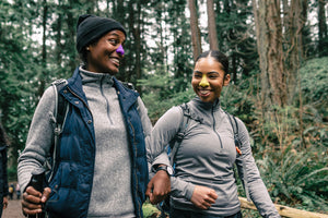 An image of two people hiking in the woods wearing our eco-friendly Nöz sunscreen